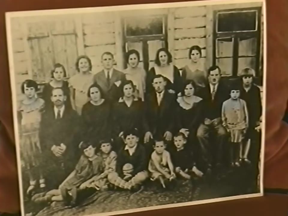 A large group portrait from 1932, several rows of adults and children in front of a house