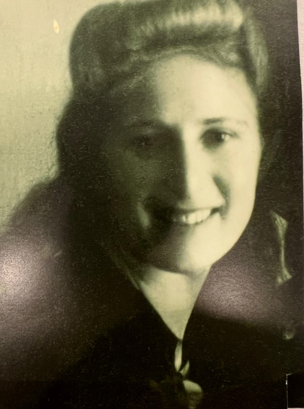 Soft portrait of Ida as a young woman, smiling, hair swept up